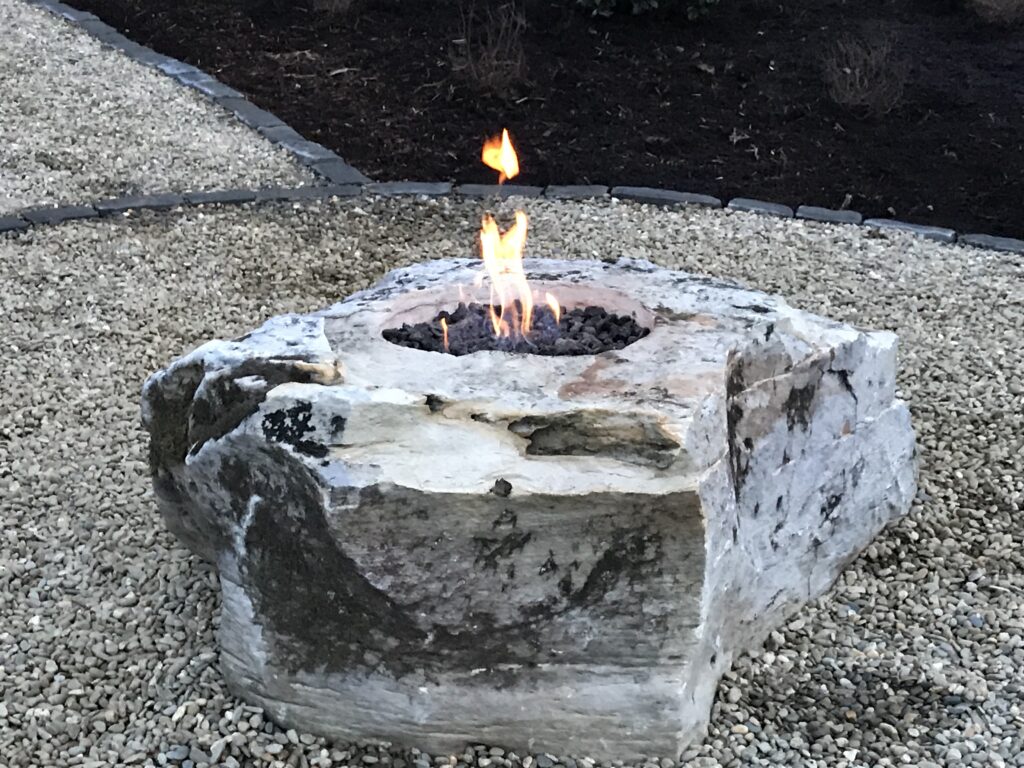 Outdoor Space - Natural stone fire pit installation with decorative gravel base and landscape edging for outdoor living space. - Garden Guru Services